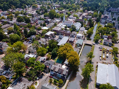 CANUE | Community Wellbeing: How to Build Communities that Support Physical, Mental, Environmental and Social Wellbeing | March 31st, 2022Scenic seasonal landscape from above aerial view of a small town in countryside of Lambertville New Jersey USA on historic city New Hope Pennsylvania US