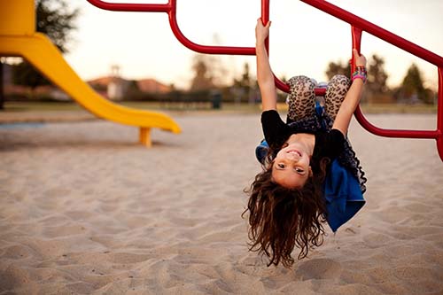 CANUE | UNICEF Report Card Echo Event: Healthy Communities for Canadian Children: Reducing Air Pollution, Increasing Access to Greenspace, and Building Playable NeighbourhoodsPortrait of girl hanging upside down on structure at park